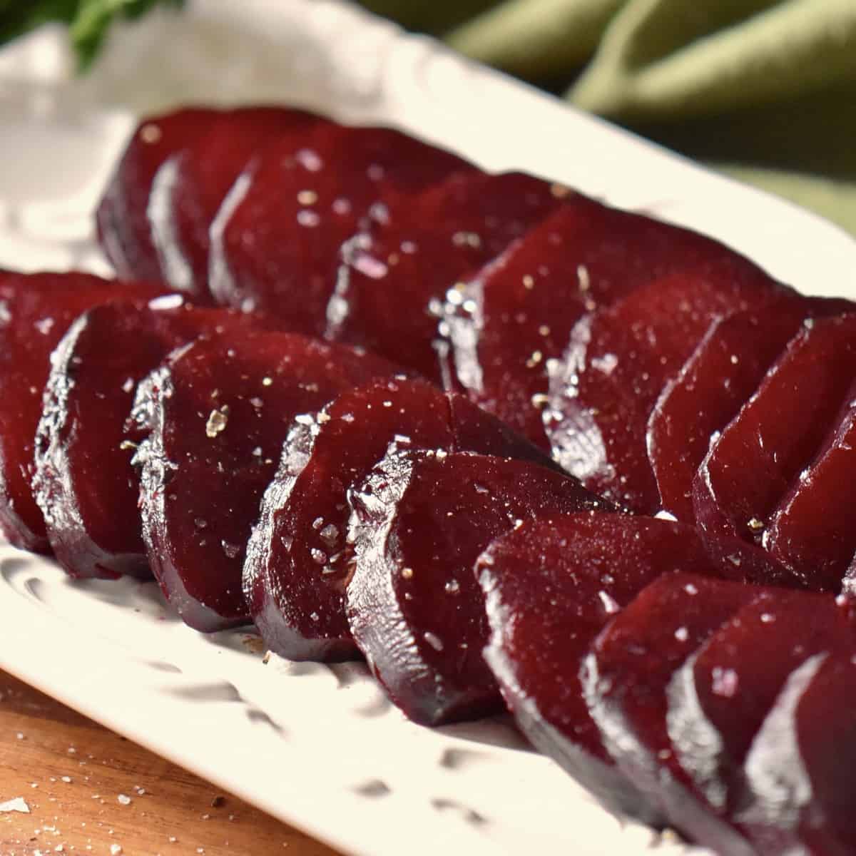 Sliced roasted beets on a white serving platter.