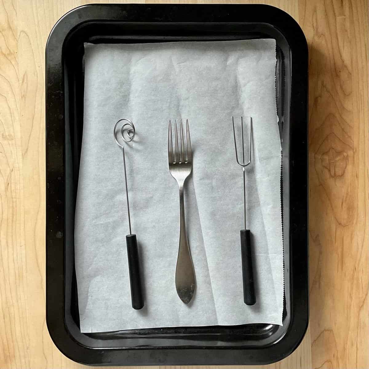 Chocolate dipping utensils on a tray. 