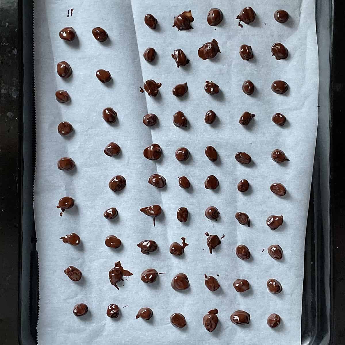 Chocolate coffee beans on parchment paper.