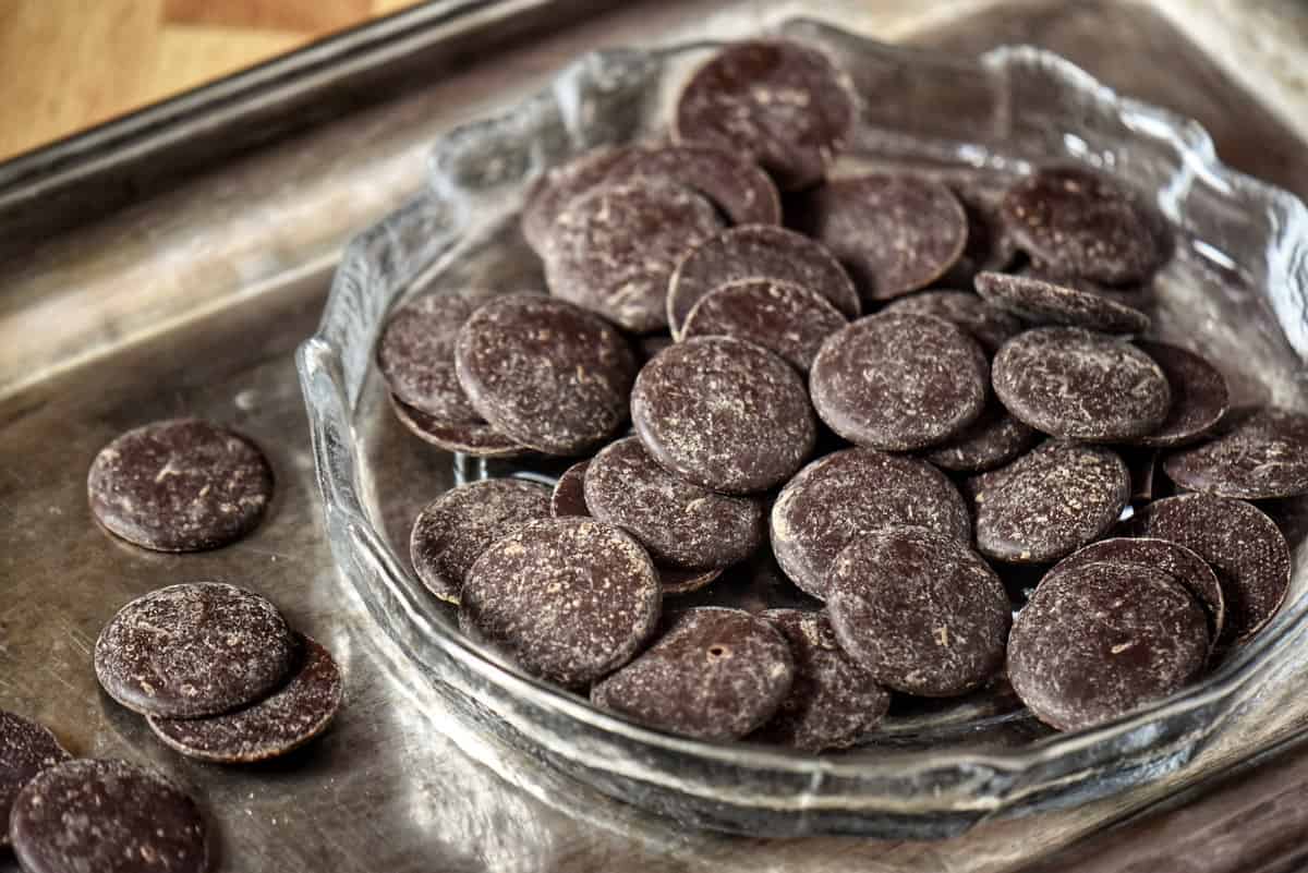 Dark chocolate discs in a bowl.