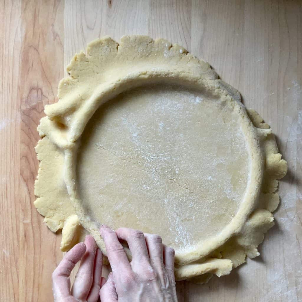 Pressing the pasta frolla dough into the springform pan.