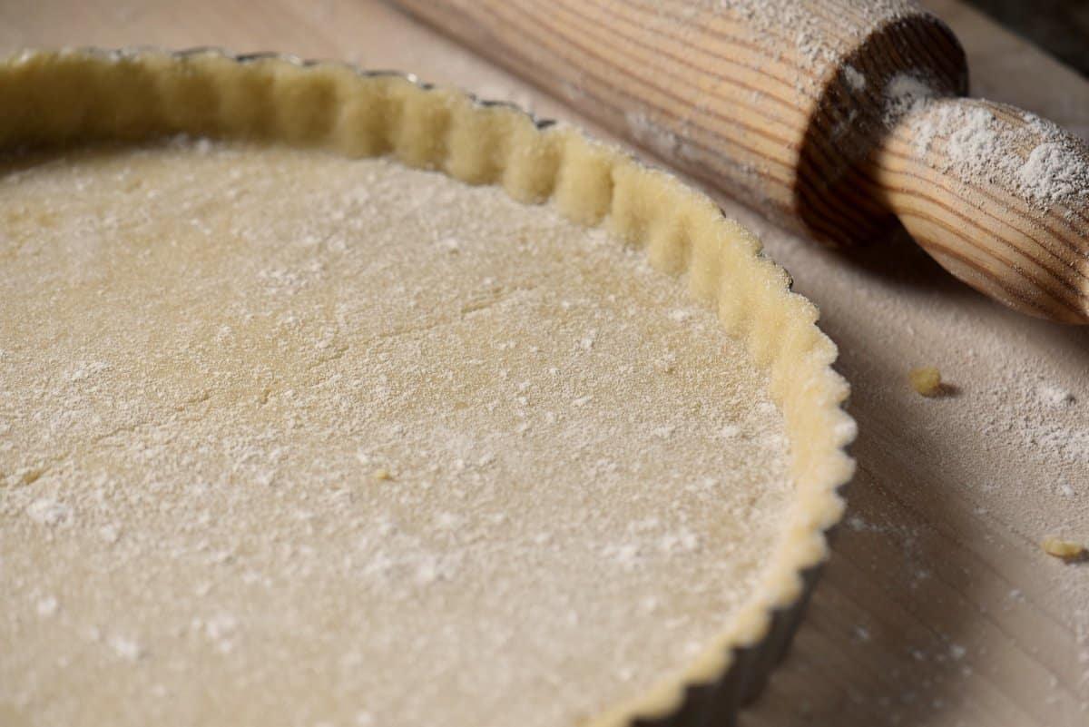 A springform pan with raw Italian sweet shortcrust pastry dough.