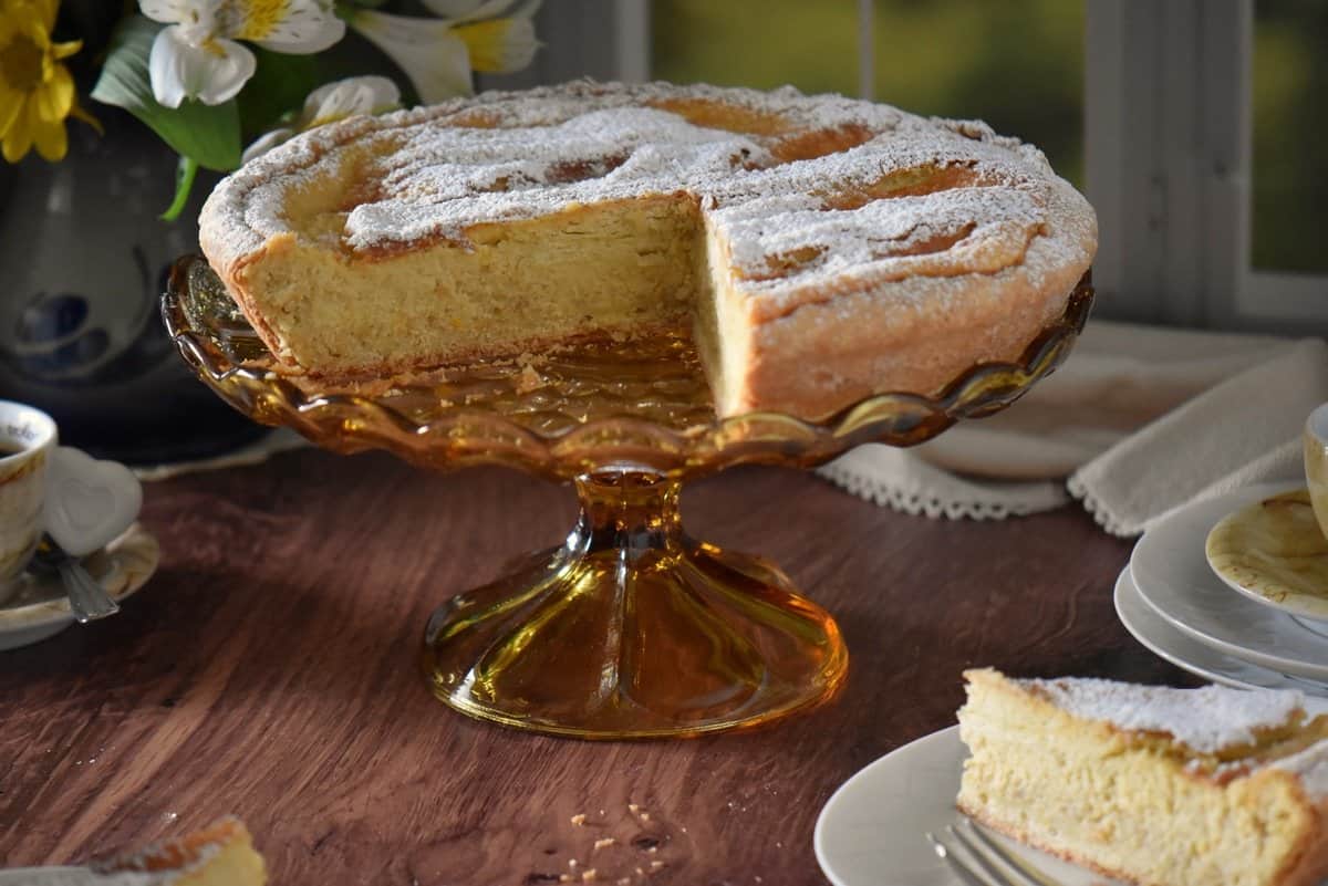 Pastiera Napoletana on an amber colored cake stand.