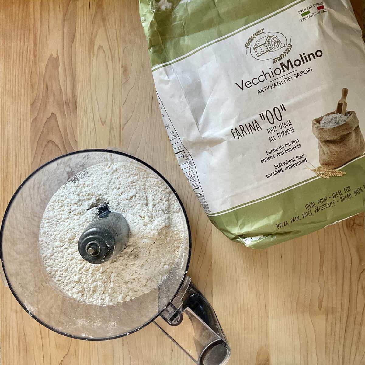 A package of Italian 00 flour next to a food processor.