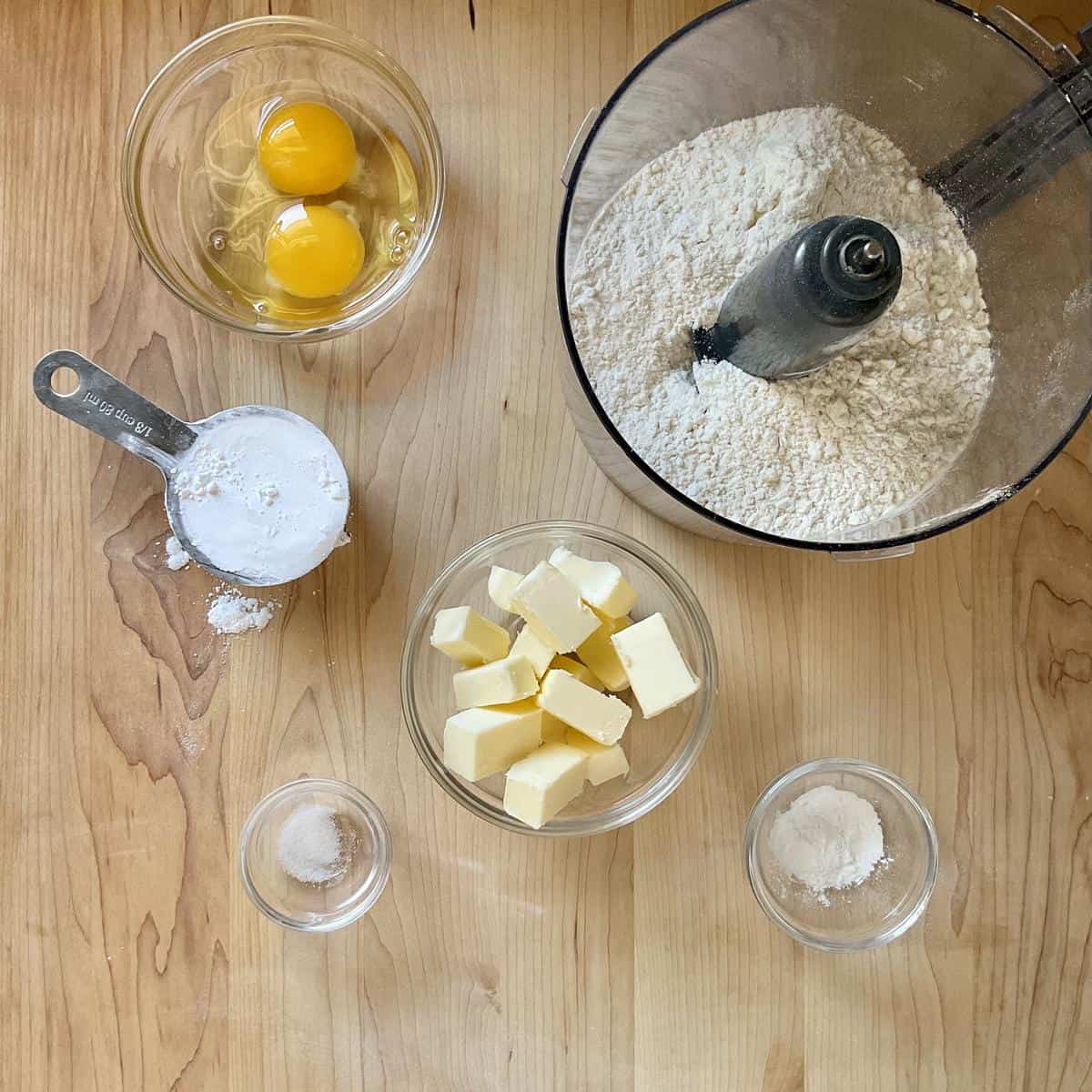 The ingredients to make pasta frolla on a wooden surface. 