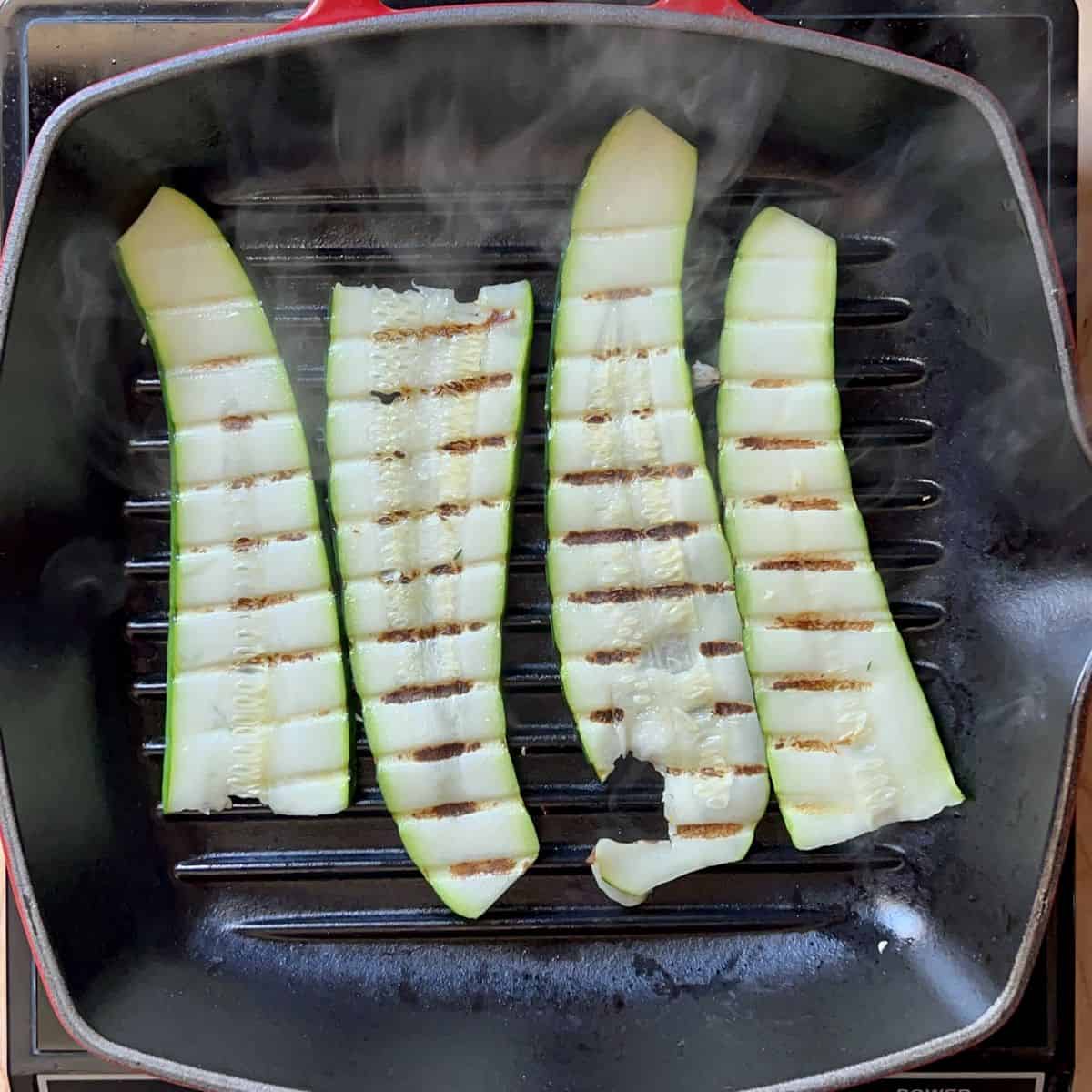 Sliced zucchini being grilled.