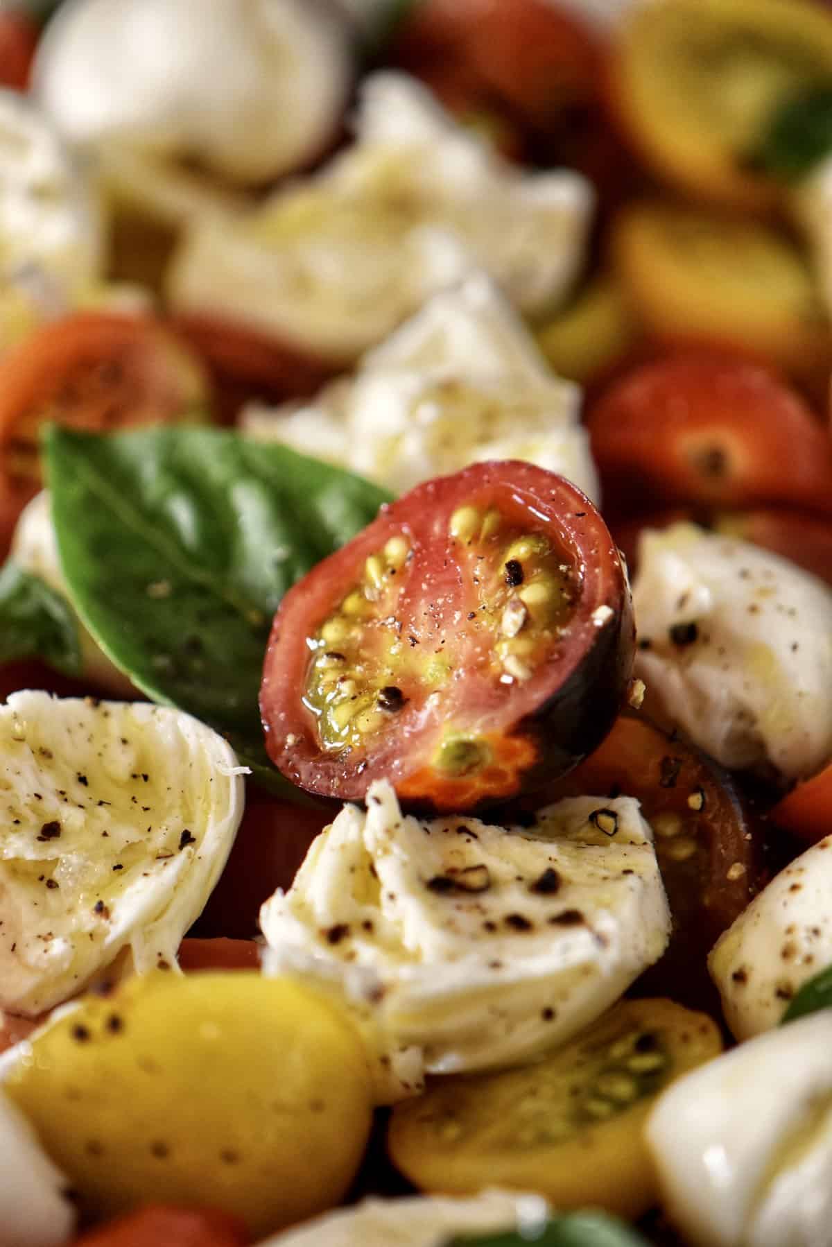 A close up photo of a caprese salad with cherry tomatoes.