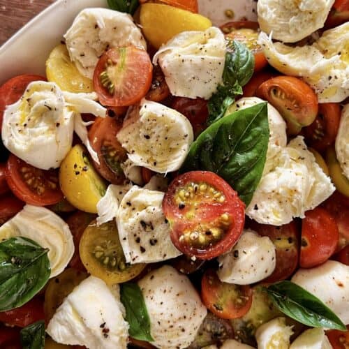 Cherry tomato Caprese salad in a white serving platter.