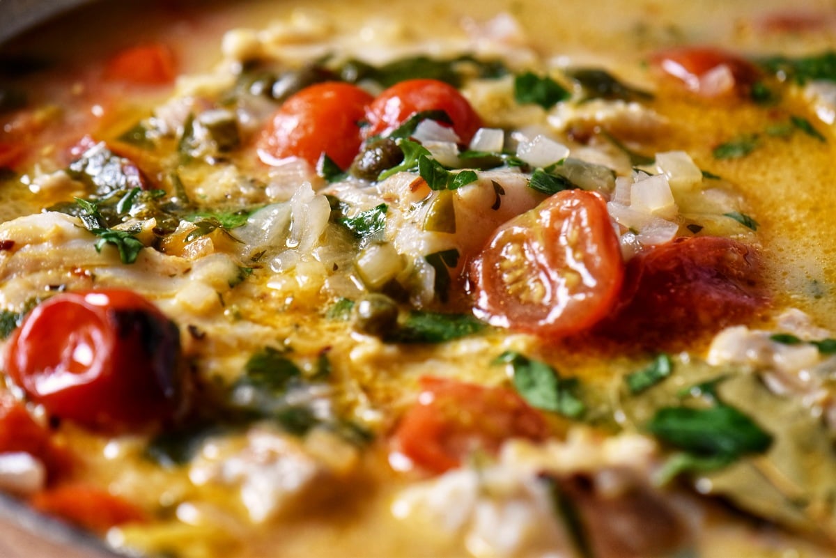 A close up photo of the cod in the flavorful herb broth.