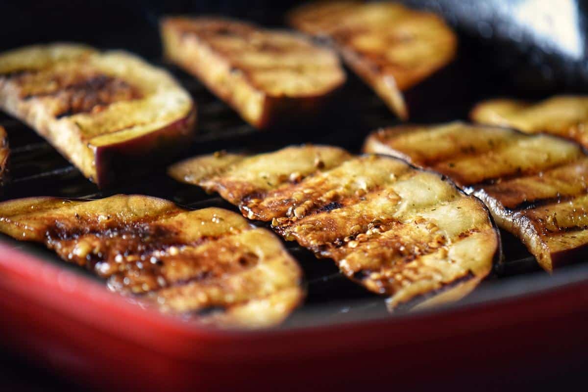 Sliced eggplants in a grill pan.