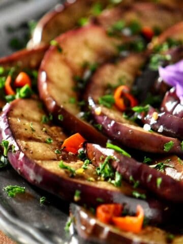 Grilled eggplants garnished with chopped parsley.