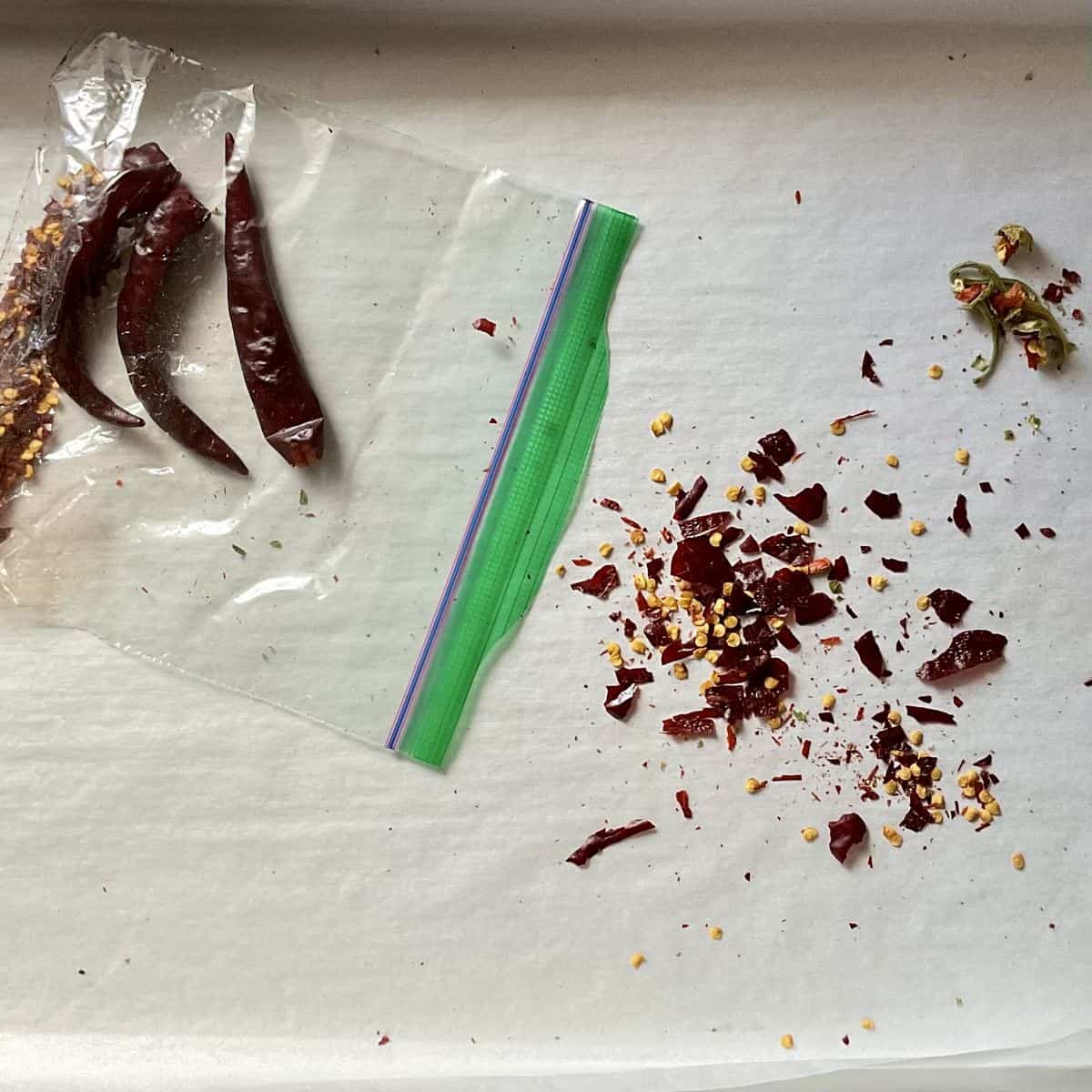 Crushed chili peppers next to a plastic bag.