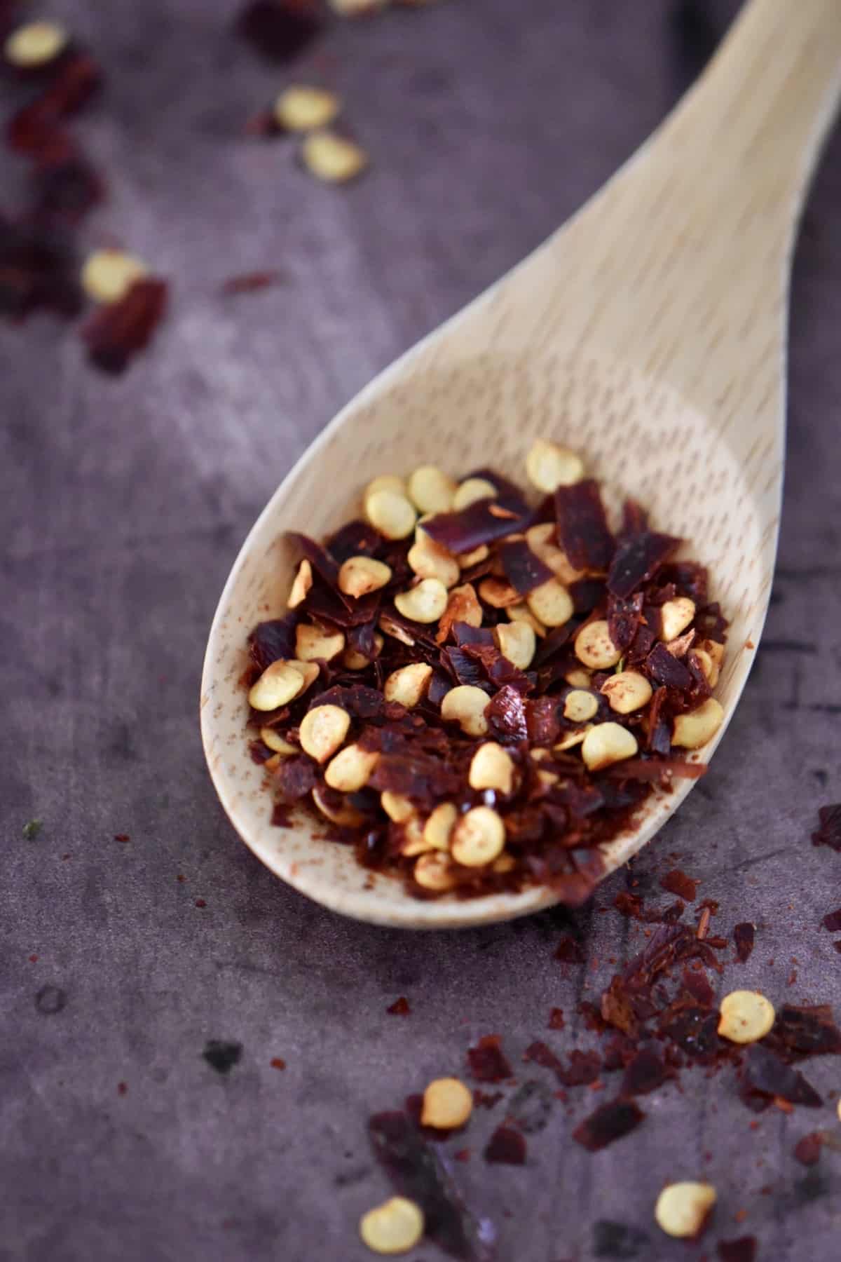 A wooden spoonful of chili flakes.