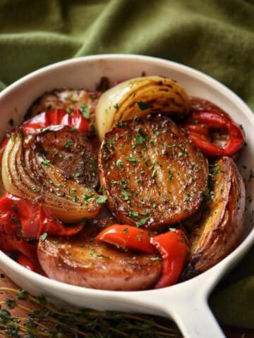 Roasted red potatoes and peppers in a white baking dish.