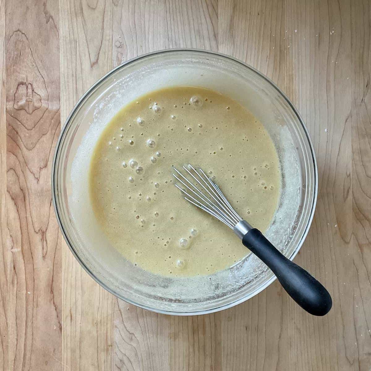 A whisk in a bowl with the wet ingredients.