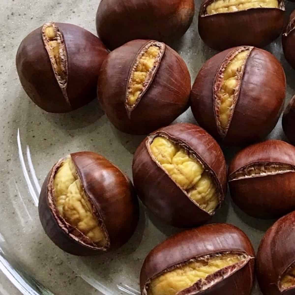 Roasted chestnuts on a glass plate.