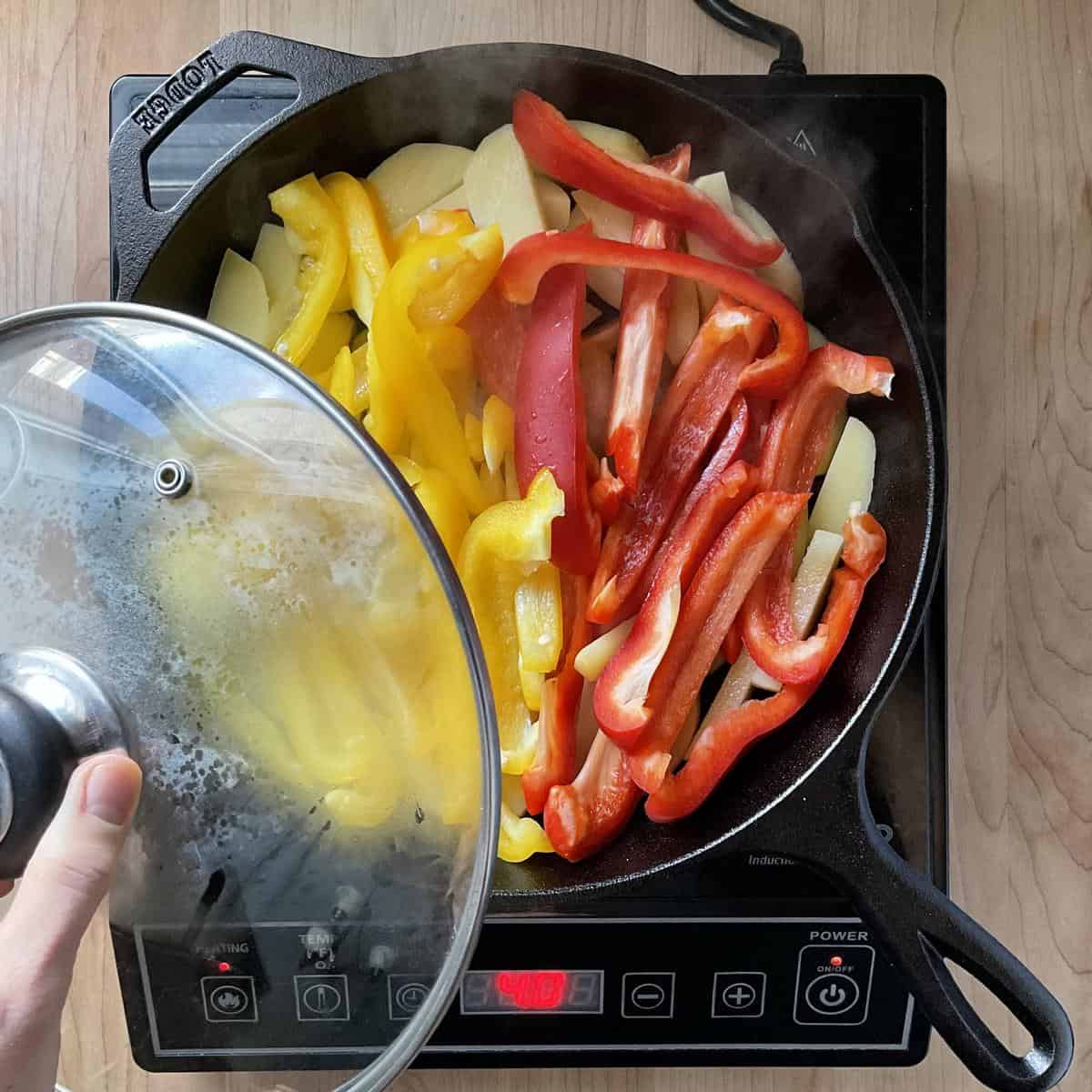 Italian peppers and potatoes in a cast iron pan.