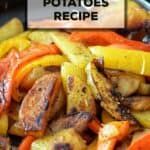 Red and yellow peppers with potatoes in a cast iron pan.