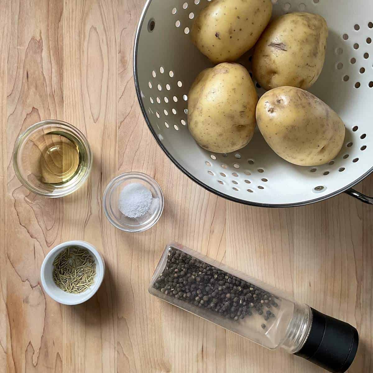 The ingredients to make skillet potatoes on a wooden board.