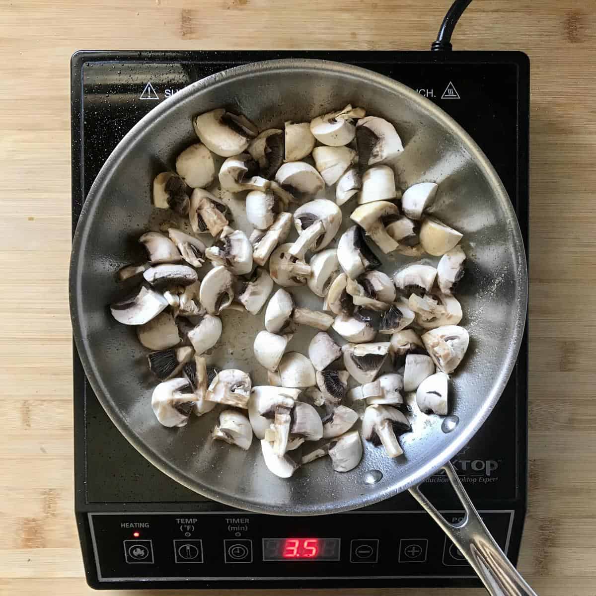 Mushrooms being sauteed in a pan.