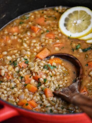 A hearty vegetable barley soup in a Dutch oven.