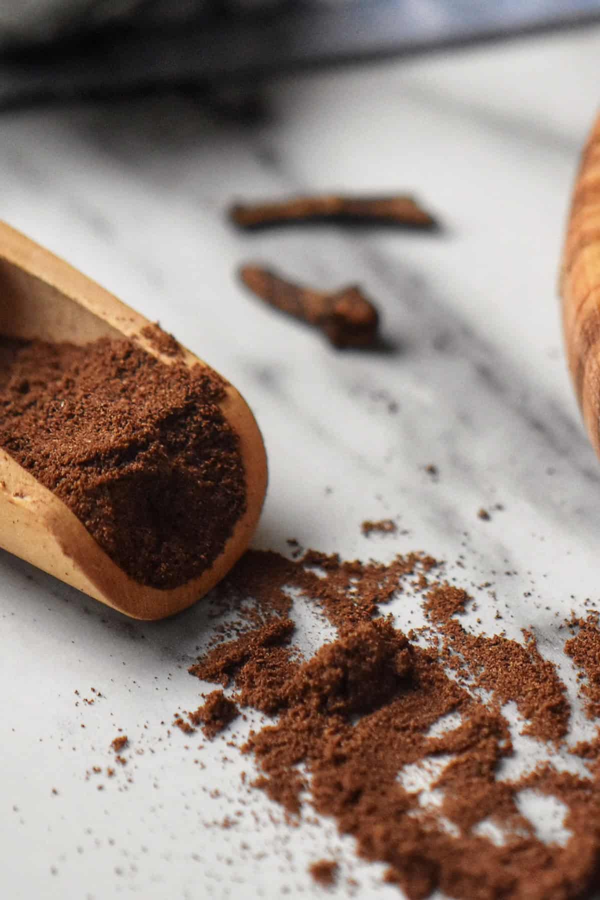 The final product of this allspice recipe can be seen scattered next to a wooden board.