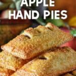 Apple hand pies stacked on white plate with cinnamon sugar topping
