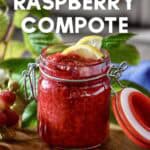 Wooden spoon holding raspberry compote with visible berry pieces.