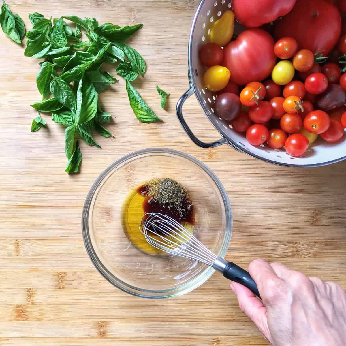 Ingredients for the tomato bruschetta marinade are being whisked together.