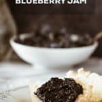A Pinterest pin of blueberry refrigerator jam on a buttermilk biscuit.