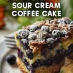 A slice of blueberry sour cream coffee cake made with oil on a white plate