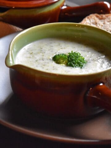 Broccoli soup garnished with a broccoli floret.