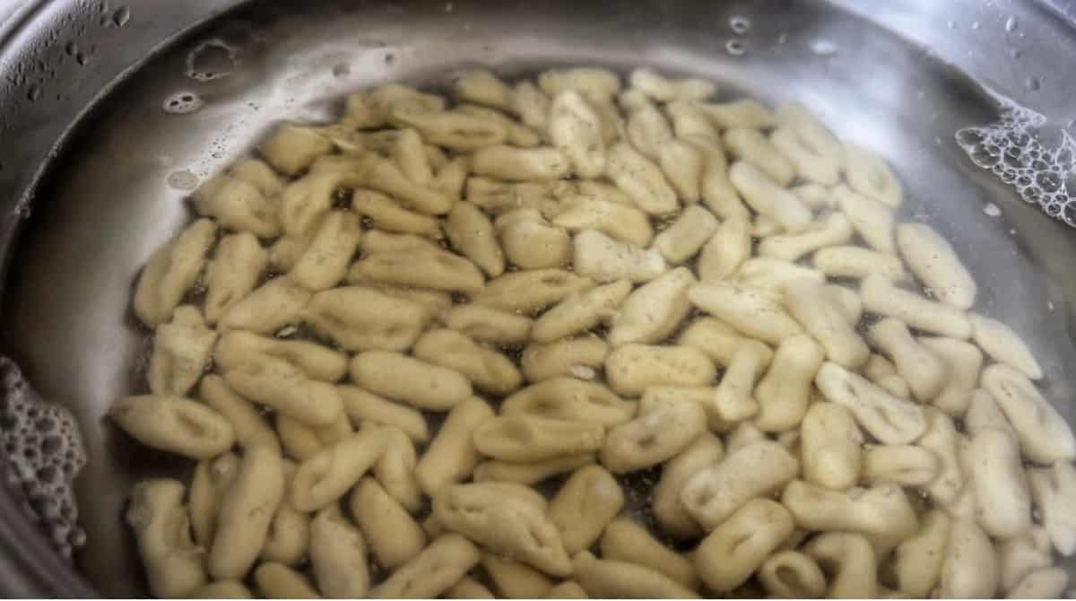 A pot of water with cavatelli floating to the top.