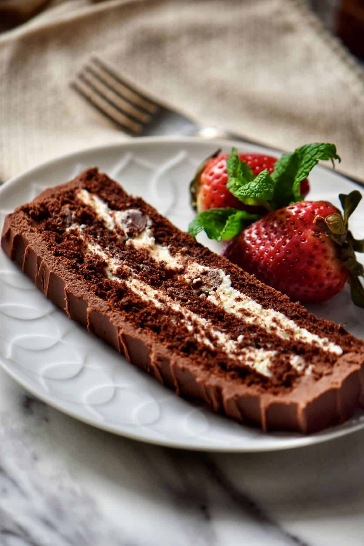 A slice of Chocolate Cake with ricotta cheese filling on a white serving plate.