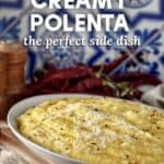Creamy Polenta in a white dish, topped with red chili flakes.