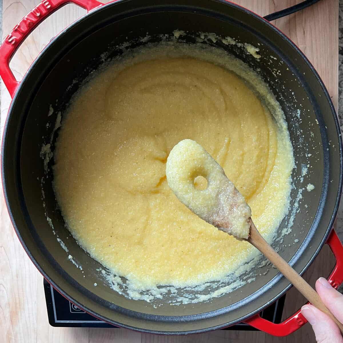 A wooden polenta spoonful of creamy polenta.