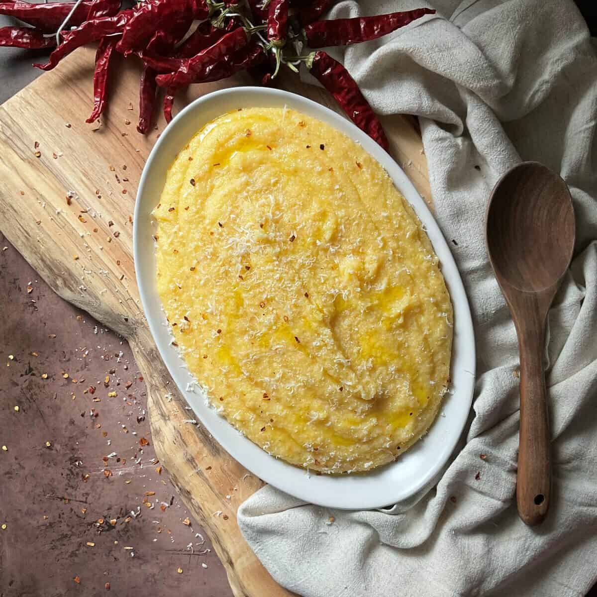 An overhead shot of Creamy Polenta and a chunk of Parmesan cheese.