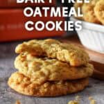 Small stack of oatmeal cookies with a bite taken from the top cookie, revealing the chewy texture inside.
