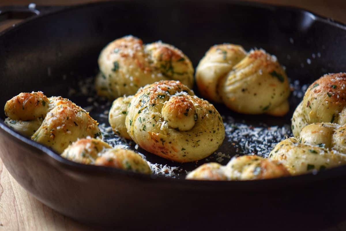 Baked garlic knots in a cast iron pan.