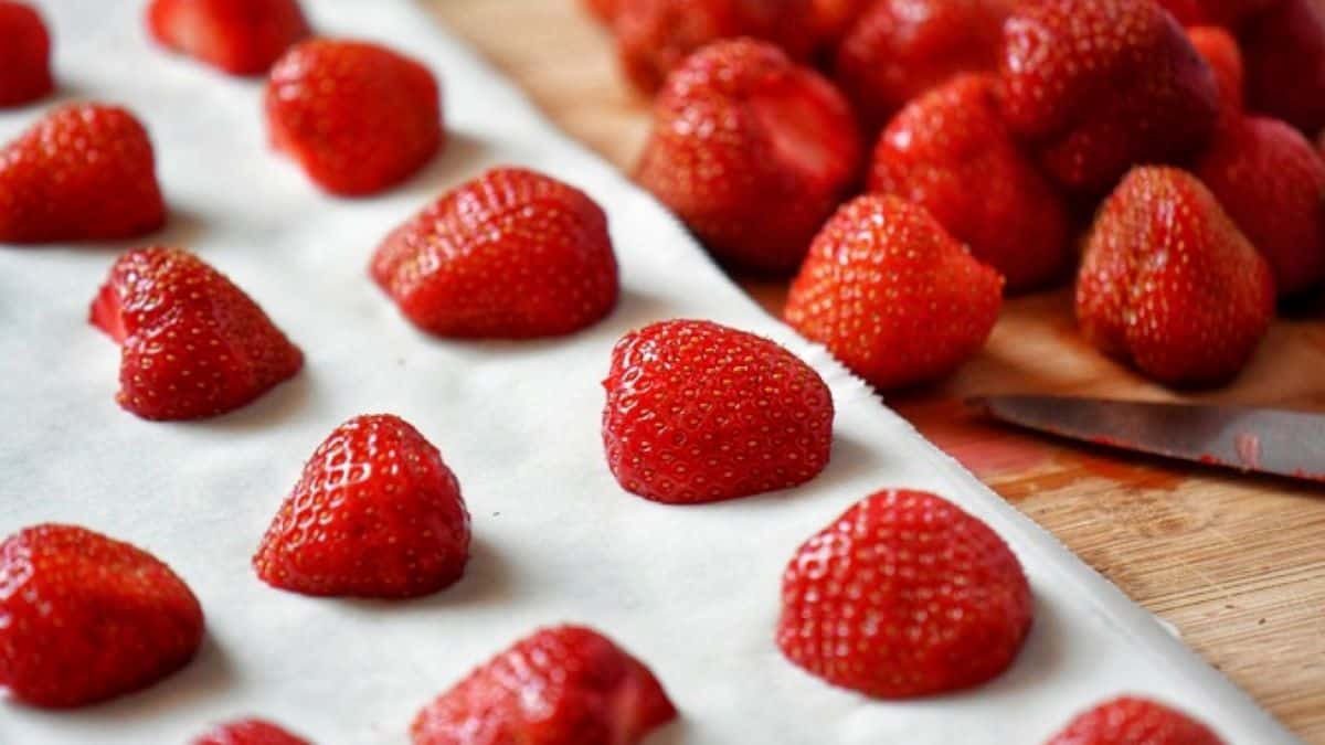 Strawberries on a baking sheet that has been lined with parchment paper.
