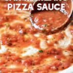 A wooden spoon with homemade pizza sauce garnishing a pizza.