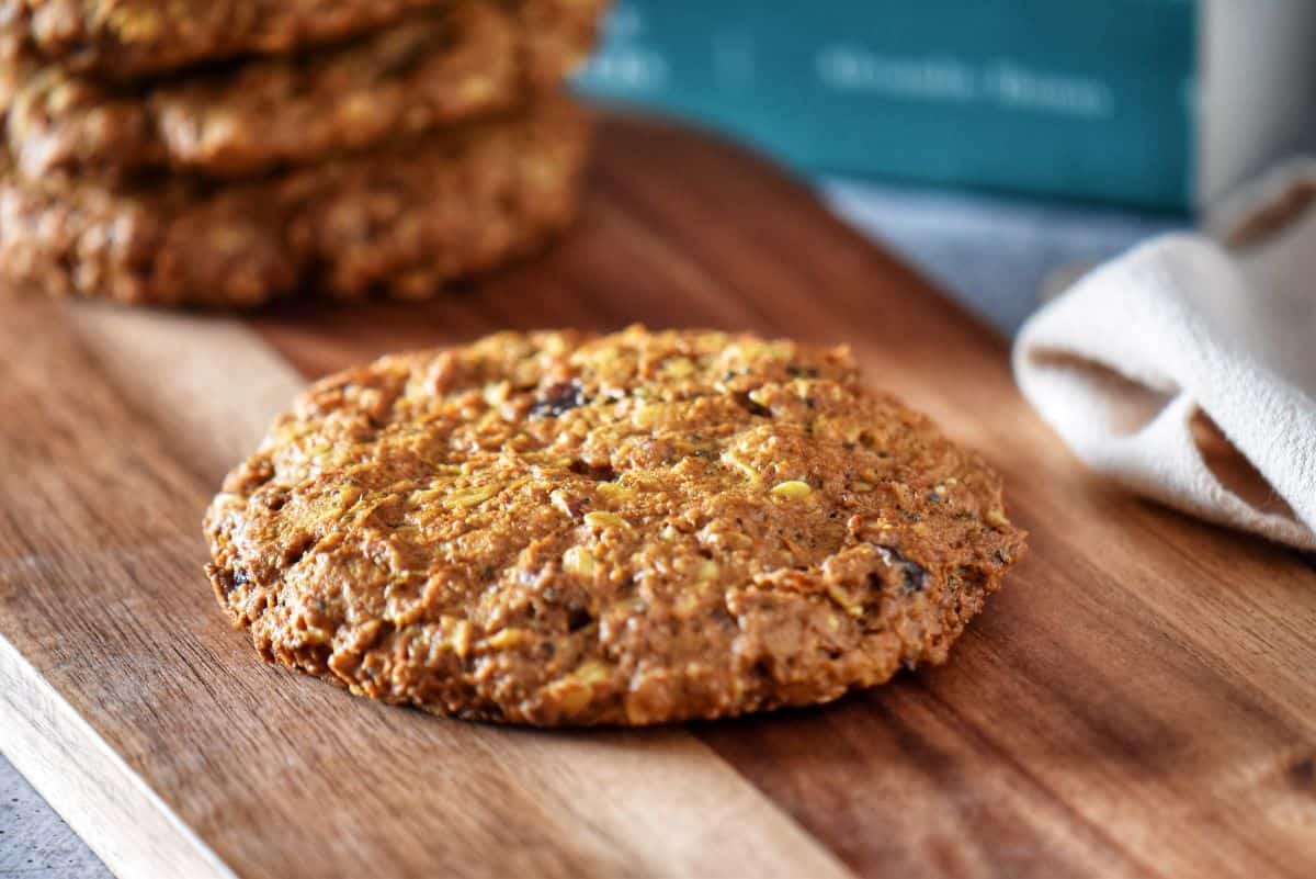A carrot oatmeal cookie on a wooden surface.