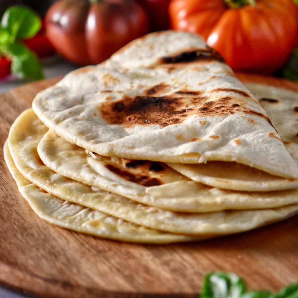 Grilled piadina on a wooden surface.