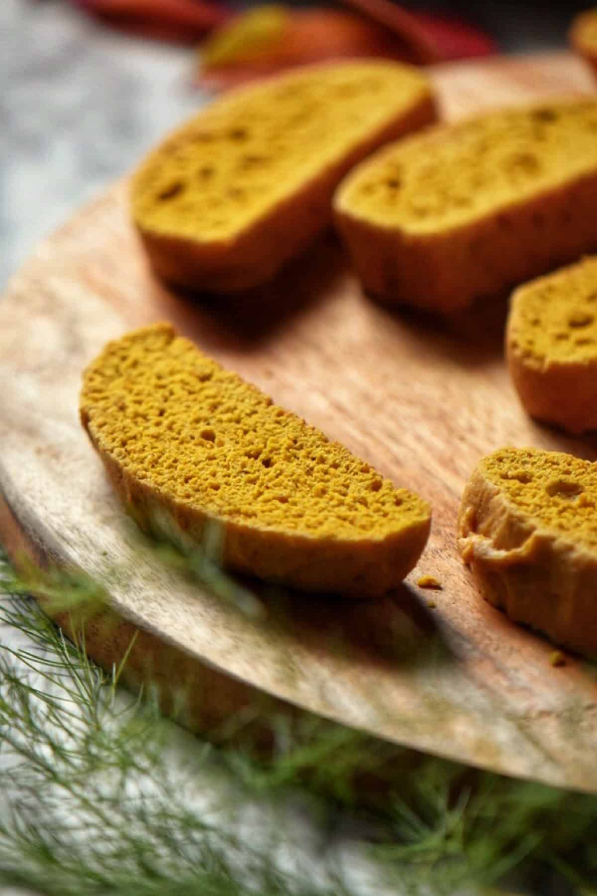 Sliced pumpkin biscotti on a wooden board.