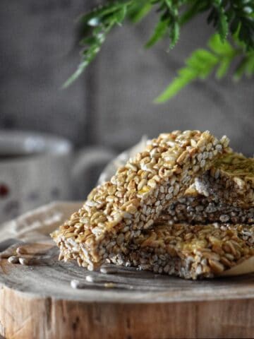 Rectangle pieces of sesame seed candy on a wooden board.