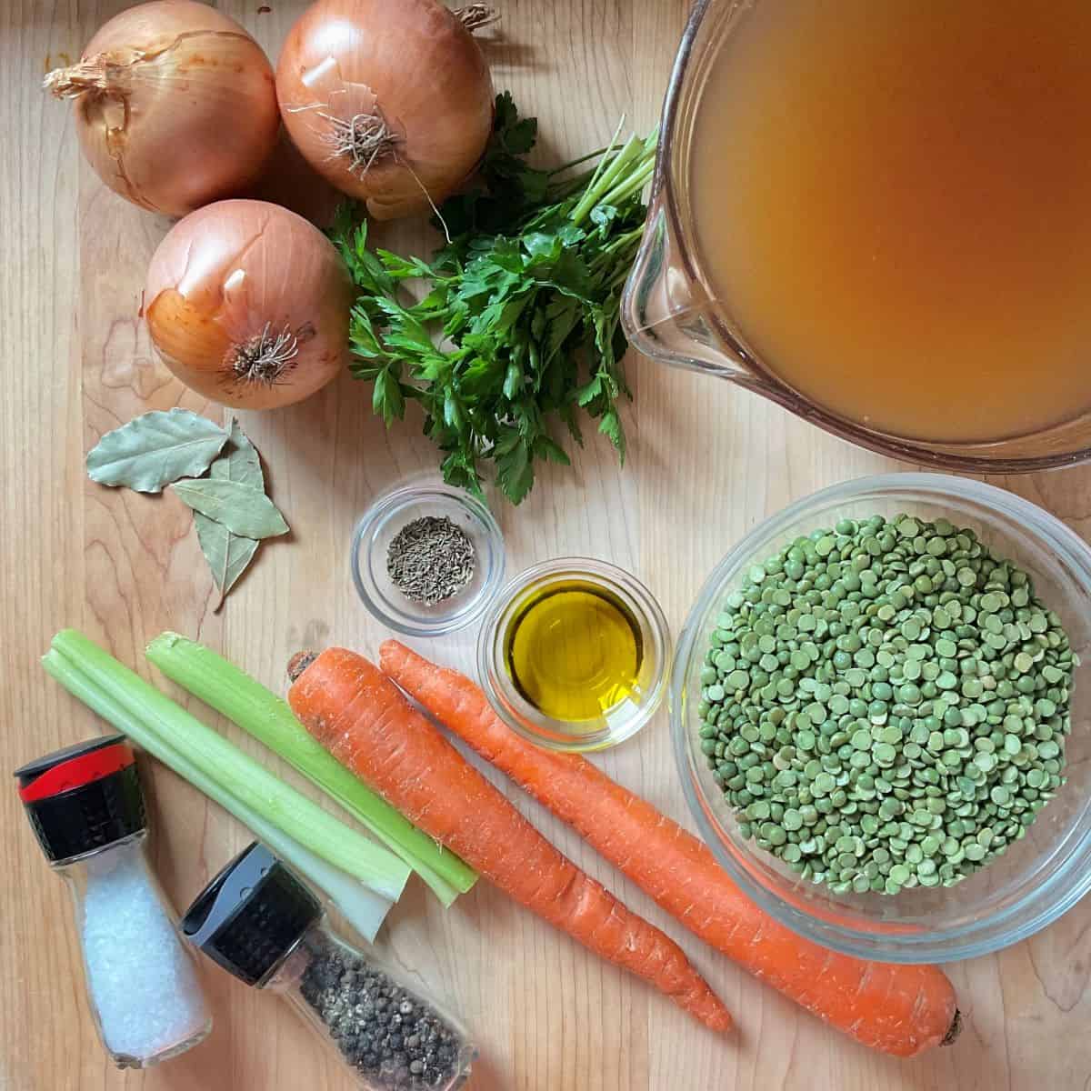 The ingredients to make a vegetarian pea soup on a wooden surface.