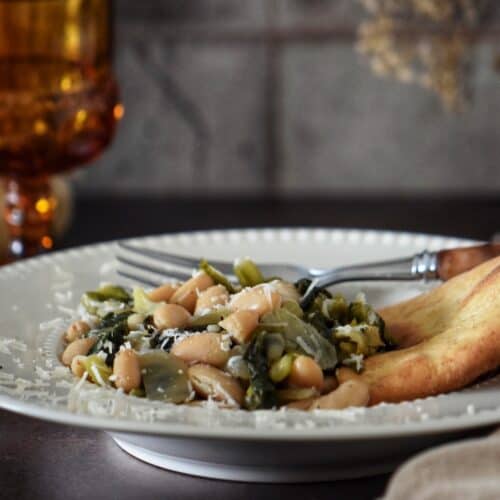 Greens and beans garnished with grated romano cheese.