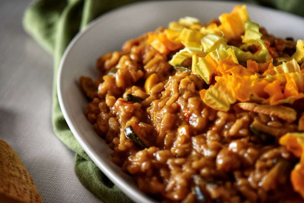 Zucchini risotto garnished with zucchini flowers.