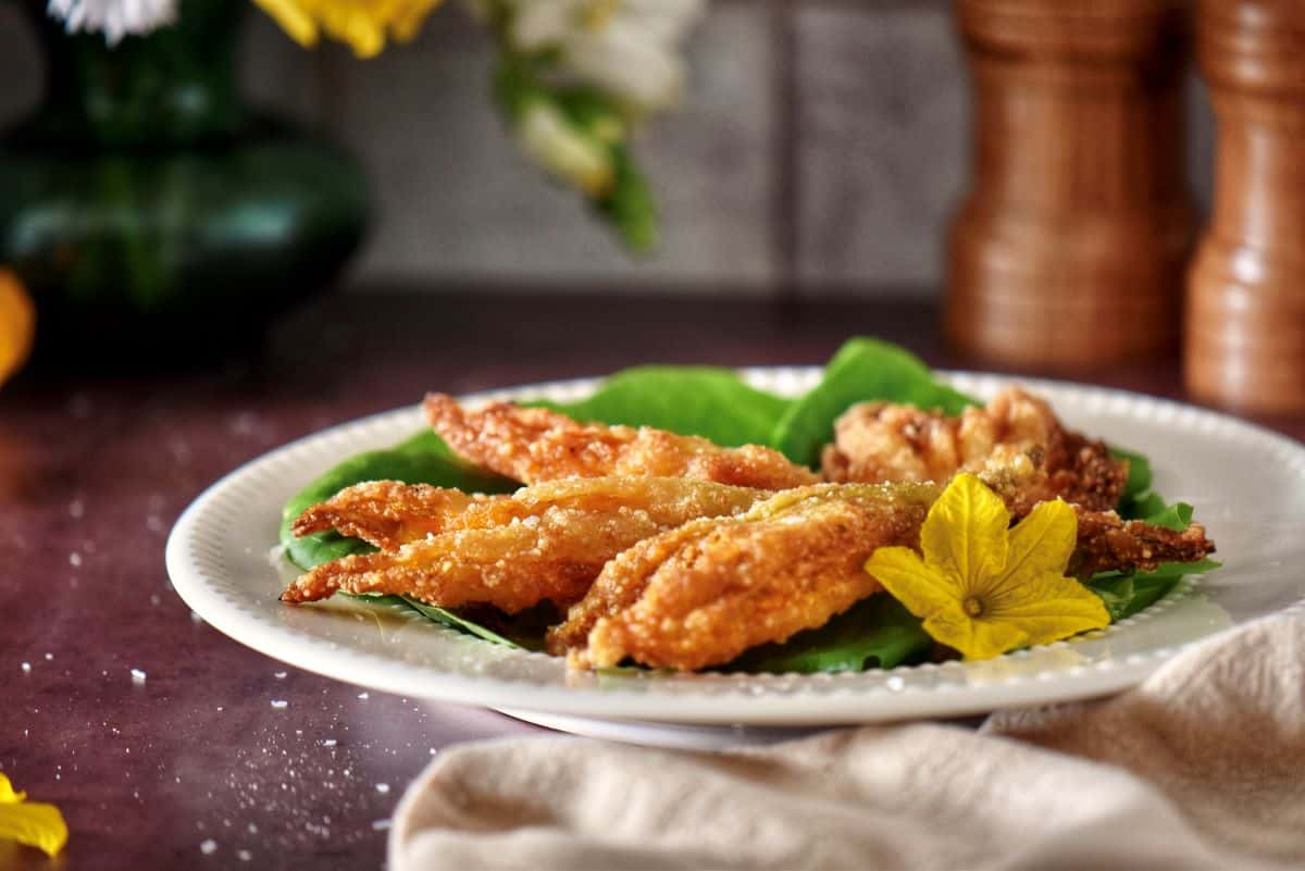 Pan-fried squash blossoms on a plate.