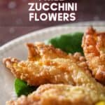 Fried zucchini flowers on a white serving dish.